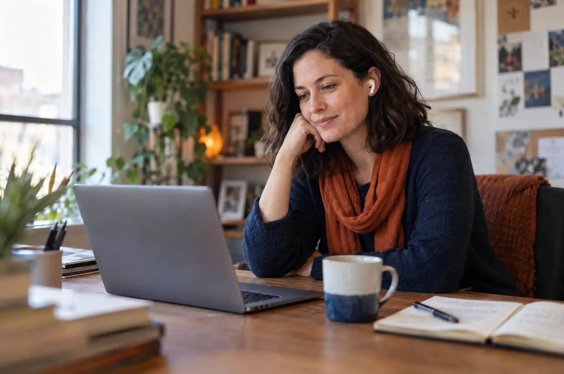 Fundraiser smiling at her laptop with coffee and a notebook, preparing for a meeting